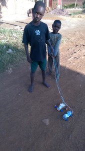 These kids made little pull cars out of empty plastic bottles