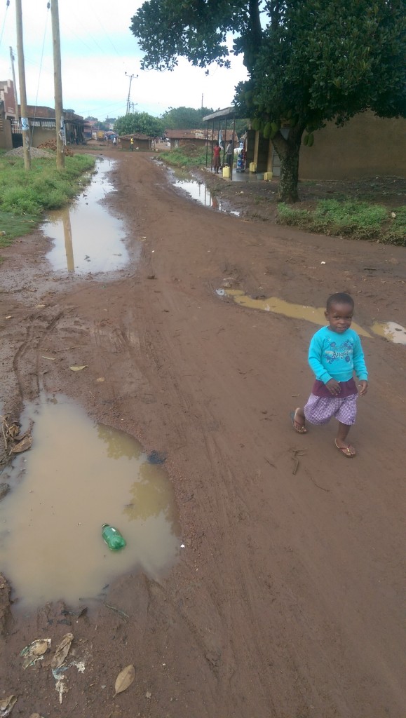 This is a road on the way to work after a heavy rain the night before. The kid is one of two really tiny ones (1-2 years old I'm guessing) who absolutely want to get to me when I pass by. I often throw them up a bit or carry them back to their home.